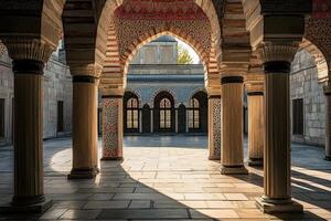 Sunlit courtyard with ornate arches, columns, and tiled walls. photo