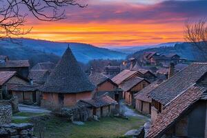 Sunrise over charming village with unique conical roofs and stone houses nestled in hills. photo