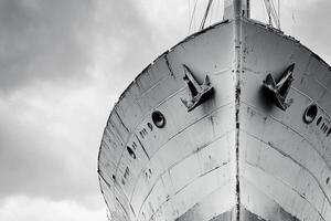 A close-up view of a ship's bow against a cloudy sky. photo