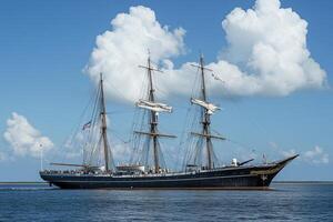 A historic sailing ship navigating calm waters. photo