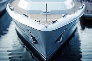 Sleek yacht bow reflecting on calm water surface. photo