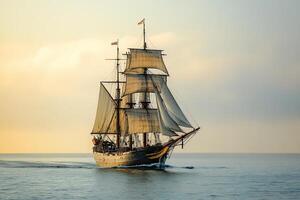 Sailing ship navigating calm waters at sunset. photo