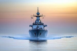 Naval ship navigating calm waters at sunset. photo