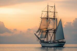 Sailing ship at sunset on calm waters. photo