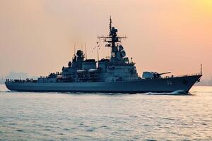 Naval warship sailing in calm waters at sunset. photo