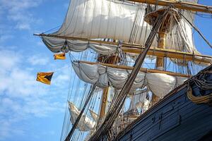 Sailing ship with billowing sails against a blue sky. photo
