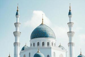 Majestic blue dome and minarets of a mosque against a clear sky. photo