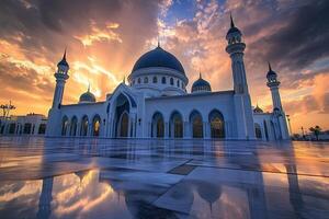 Majestic white mosque reflecting in a wet plaza at sunset. photo