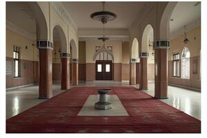 Mosque interior with arches, columns, and carpet. photo