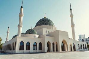 Majestic white mosque with teal domes under a clear sky. photo