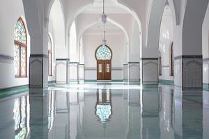 Reflective floor in a mosque's interior with arched entryway and stained-glass windows. photo