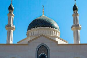 Mosque dome and minarets against a clear blue sky. photo