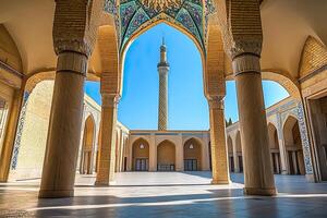 Mosque courtyard with tall minaret under blue sky. photo
