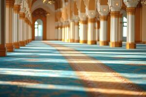 Sunlit mosque interior with rows of columns and blue carpet. photo