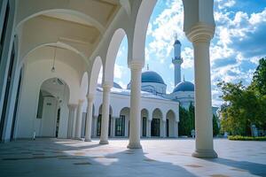 Sunlit mosque courtyard with arched colonnade. photo
