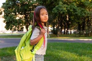 Confident young girl with backpack in park, embracing outdoor adventure and learning photo