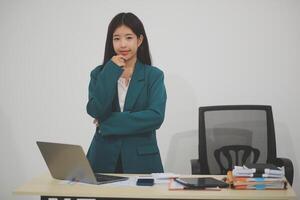Asian Business woman using calculator and laptop for doing math finance on an office desk, tax, report, accounting, statistics, and analytical research concept photo