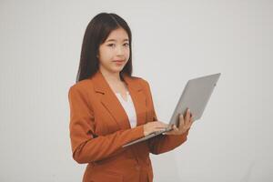 Young beautiful Asian woman in business office standing use tablet in hand, Thai girl enjoy browsing for online shopping store with copy space for advertisement, on isolated white background photo