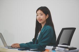 Beautiful Asian businesswoman work using a tablet and a laptop with documents placed at the office. photo