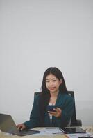 Attractive asian woman using a laptop PC and a smart phone. photo