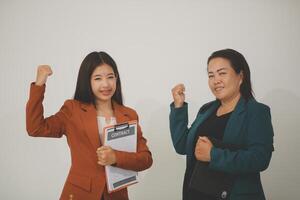 Two young professional women looking at a digital tablet isolated on white background photo