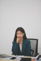 Asian Business woman using calculator and laptop for doing math finance on an office desk, tax, report, accounting, statistics, and analytical research concept photo