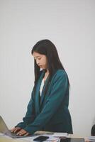 Asian Business woman using calculator and laptop for doing math finance on an office desk, tax, report, accounting, statistics, and analytical research concept photo