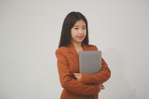 Young beautiful Asian woman in business office standing use tablet in hand, Thai girl enjoy browsing for online shopping store with copy space for advertisement, on isolated white background photo