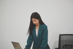 Asian Business woman using calculator and laptop for doing math finance on an office desk, tax, report, accounting, statistics, and analytical research concept photo