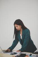 Asian Business woman using calculator and laptop for doing math finance on an office desk, tax, report, accounting, statistics, and analytical research concept photo