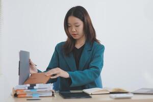Asian professional businesswoman working on tablet computer in a corporate office photo