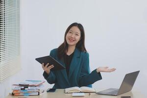Asian professional businesswoman working on tablet computer in a corporate office photo