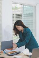 Asian professional businesswoman working on tablet computer in a corporate office photo