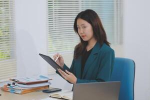 Asian professional businesswoman working on tablet computer in a corporate office photo
