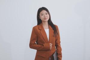 Attractive smiling Asian businesswoman standing holding tablet working and recording work details in office. photo