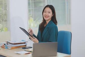 Asian professional businesswoman working on tablet computer in a corporate office photo
