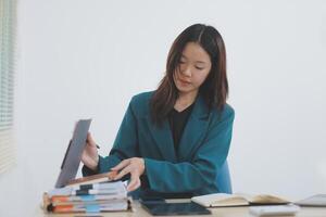 Asian professional businesswoman working on tablet computer in a corporate office photo