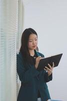 business woman working with laptop while consulting some invoice and document in working space at home photo