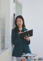 business woman working with laptop while consulting some invoice and document in working space at home photo