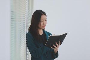 business woman working with laptop while consulting some invoice and document in working space at home photo