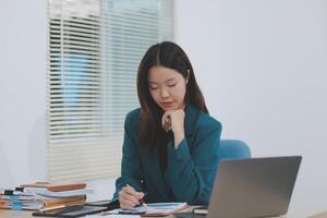 Asian professional businesswoman working on tablet computer in a corporate office photo