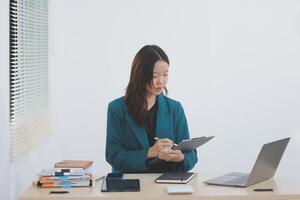 Asian professional businesswoman working on tablet computer in a corporate office photo