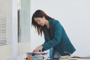 Asian professional businesswoman working on tablet computer in a corporate office photo