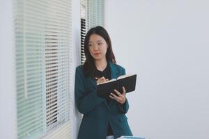 business woman working with laptop while consulting some invoice and document in working space at home photo