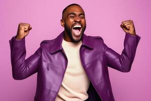 Overjoyed African American man dressed stylish clothes celebrate success raise hands fists isolated on purple color background photo