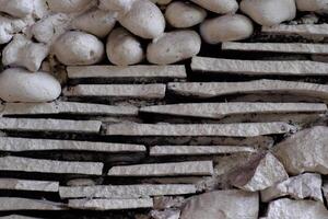 Close-up of a textured wall featuring an irregular pattern of stone and concrete. Ideal for abstract stone texture background design inspiration. photo