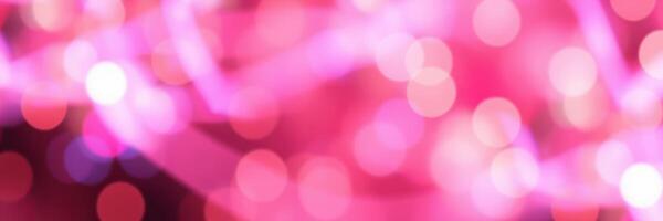 Bright pink bokeh lights create a festive atmosphere at night event in a vibrant city setting photo