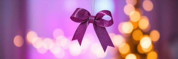 Decorative purple bow hanging with soft bokeh lights for festive celebration in indoor setting photo