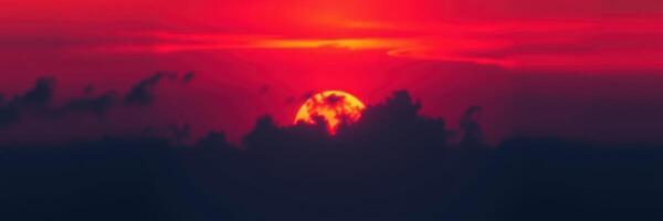 Vibrant sunset casts warm hues over dramatic clouds at dusk photo