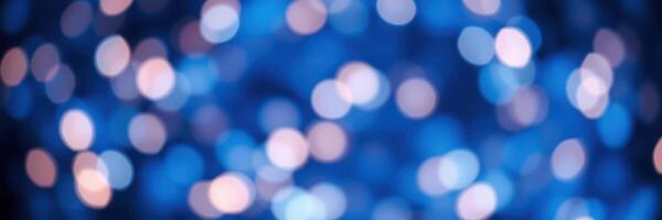 Beautiful bokeh lights create a mesmerizing abstract background in vibrant blue and soft white tones during an evening gathering photo
